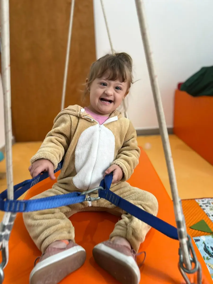 Criança sorrindo em sessão de terapia